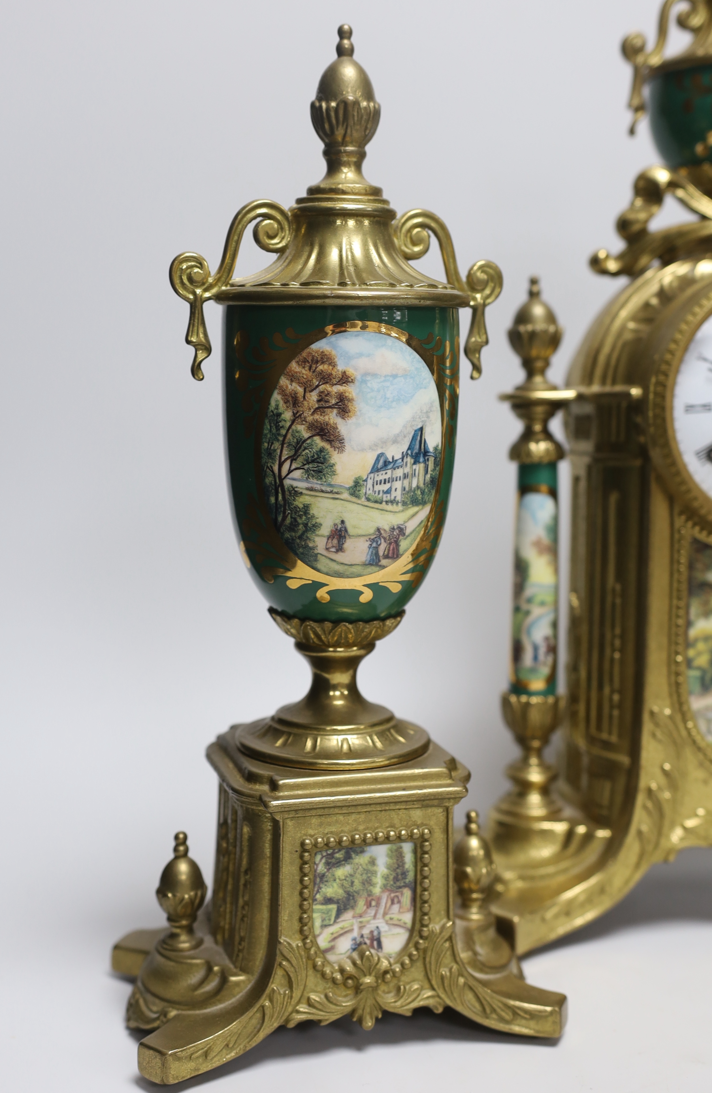 A three piece brass and porcelain clock garniture, clock 43cm high